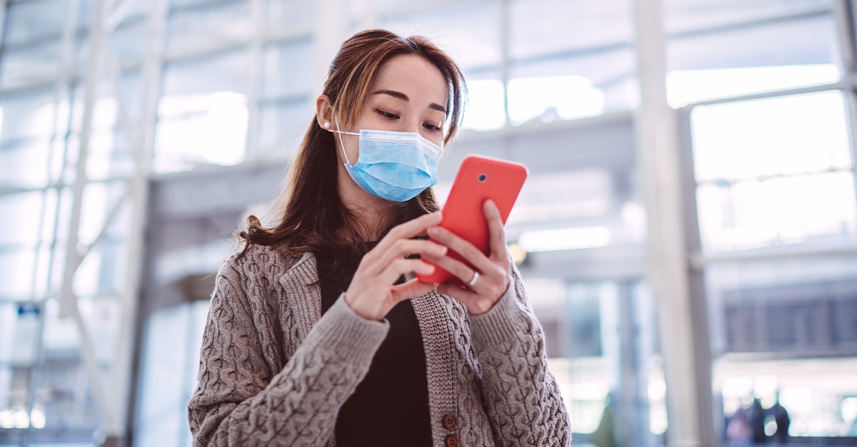 woman in mask using phone