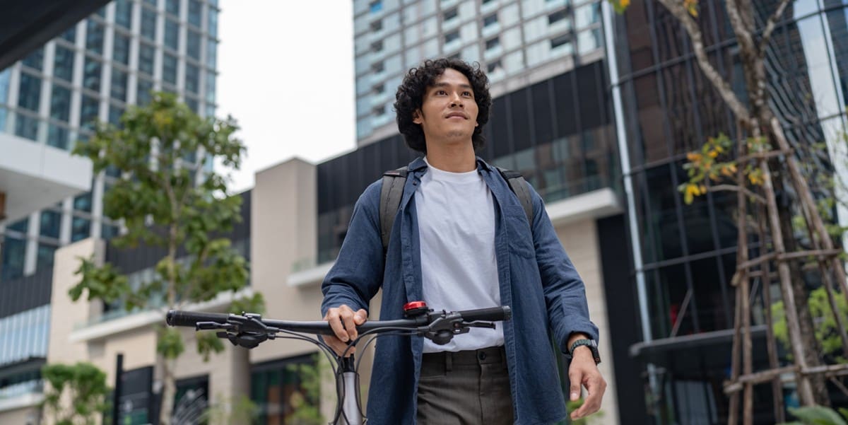 man with a bicycle, standing outside an office building