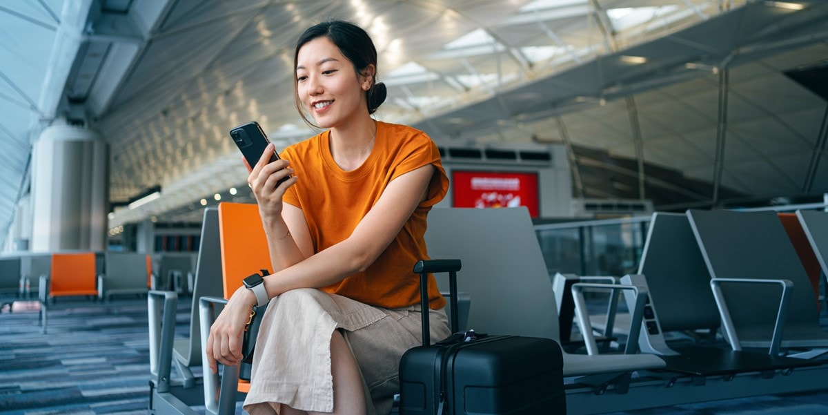 woman sitting in an airport lounge using a cell phone