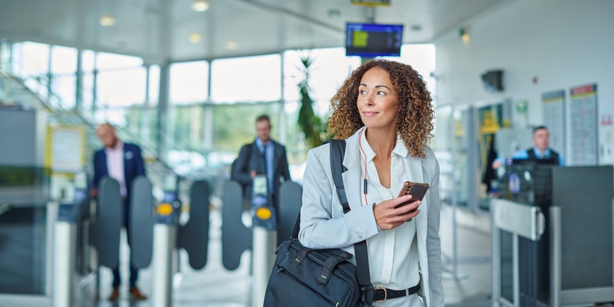 businesswoman in an office building lobby, holding cellphone