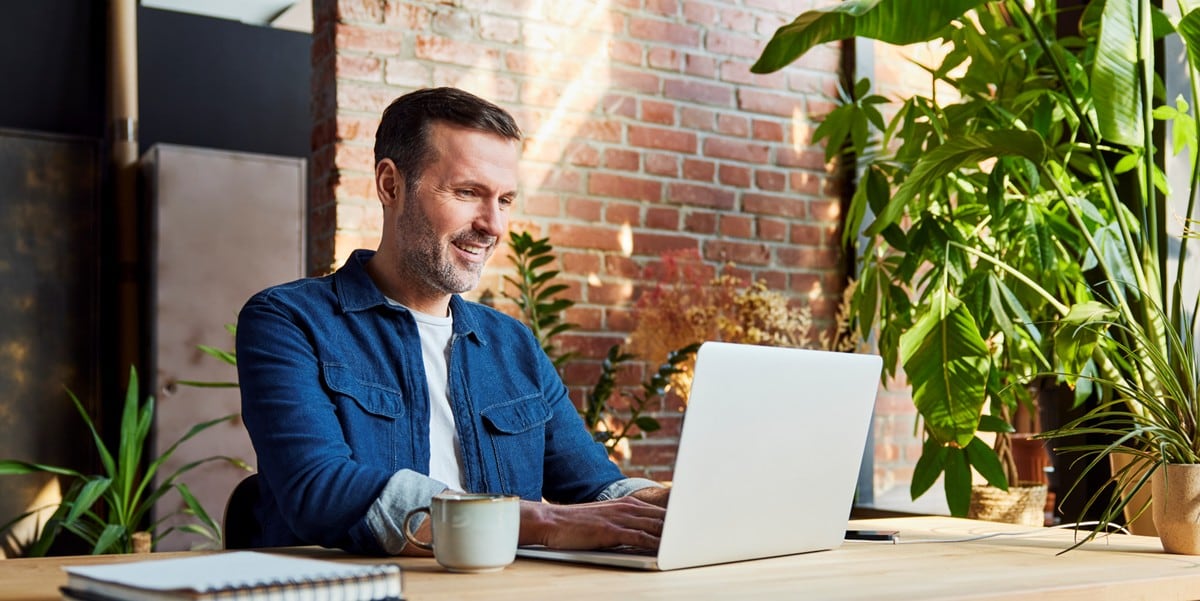 man working at a desk, using laptop