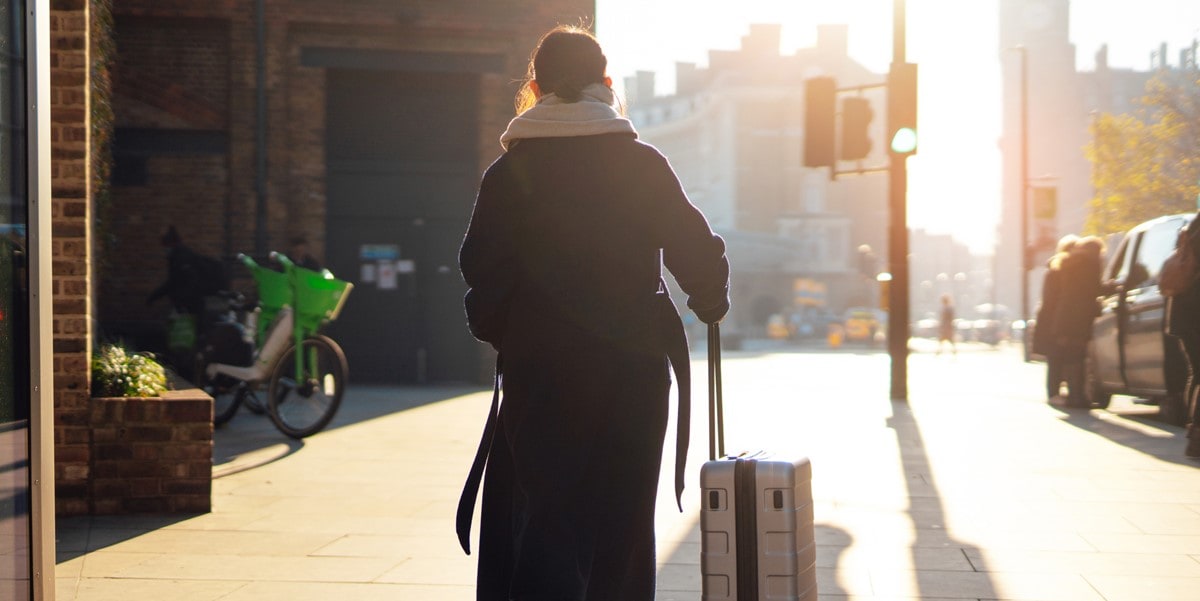 traveler walking down street with luggage