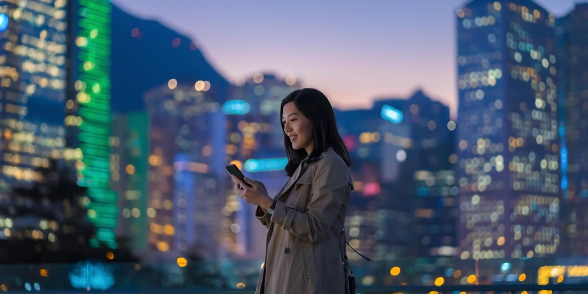 woman standing outside with skyscrapers in the bakground