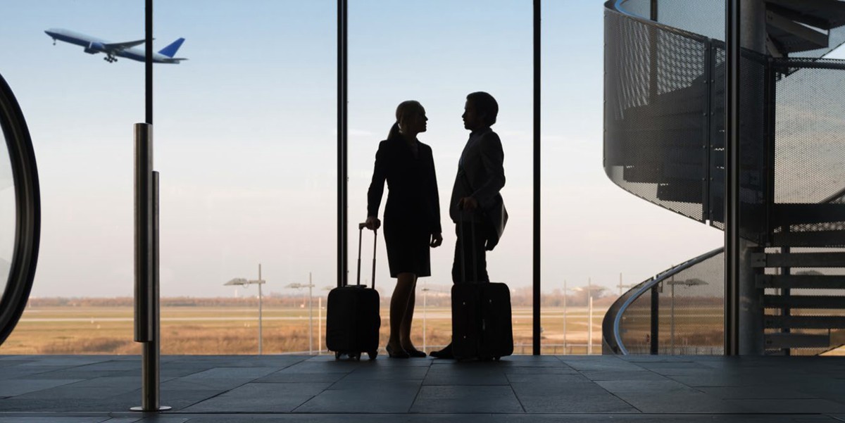 two travelers in airport with luggage