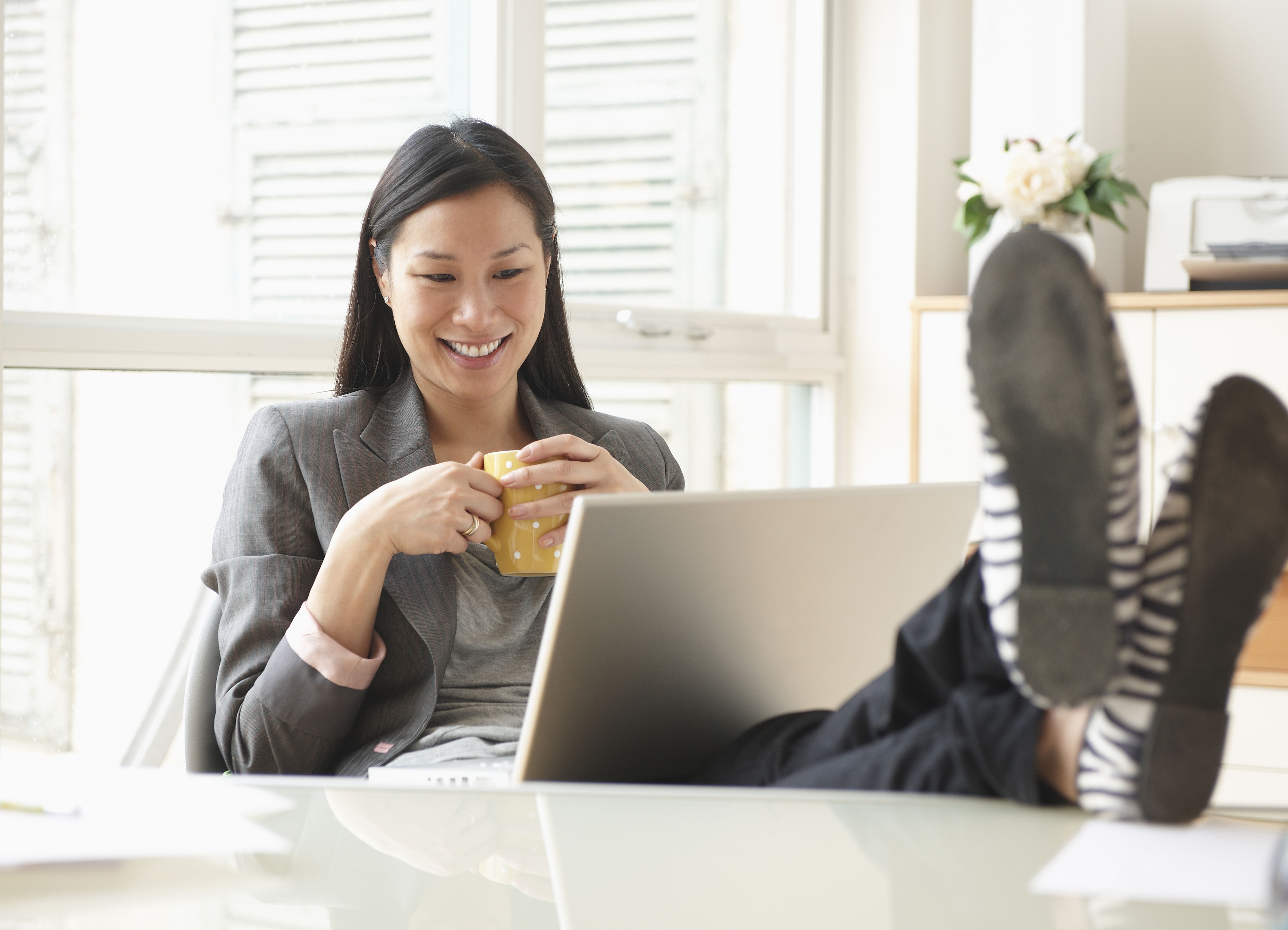 woman with coffee working on a laptop