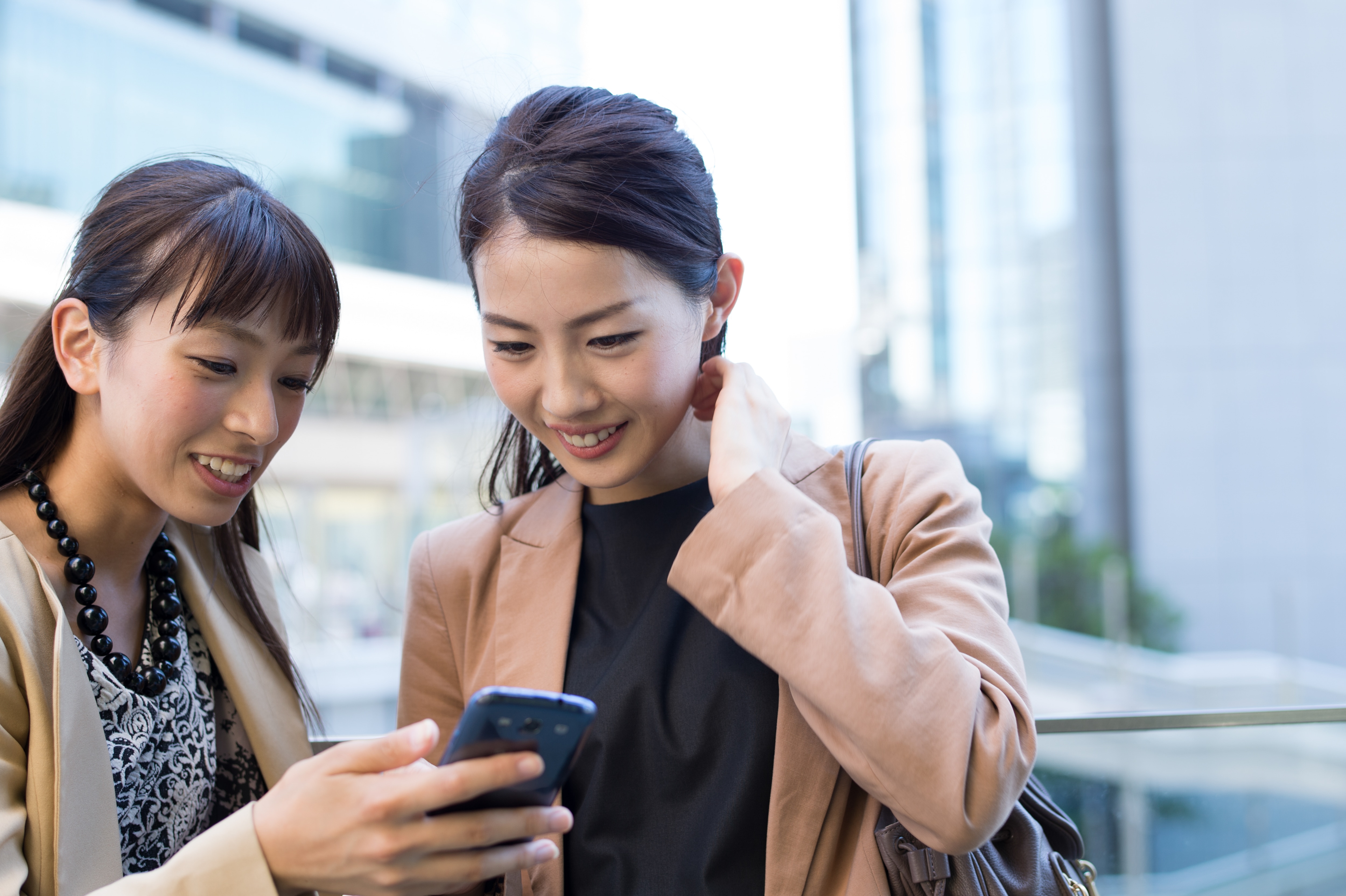 two women looking at a phone together