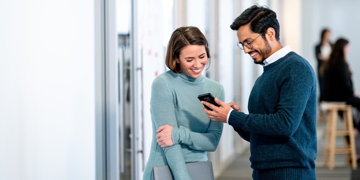 two professionals in office looking at a document