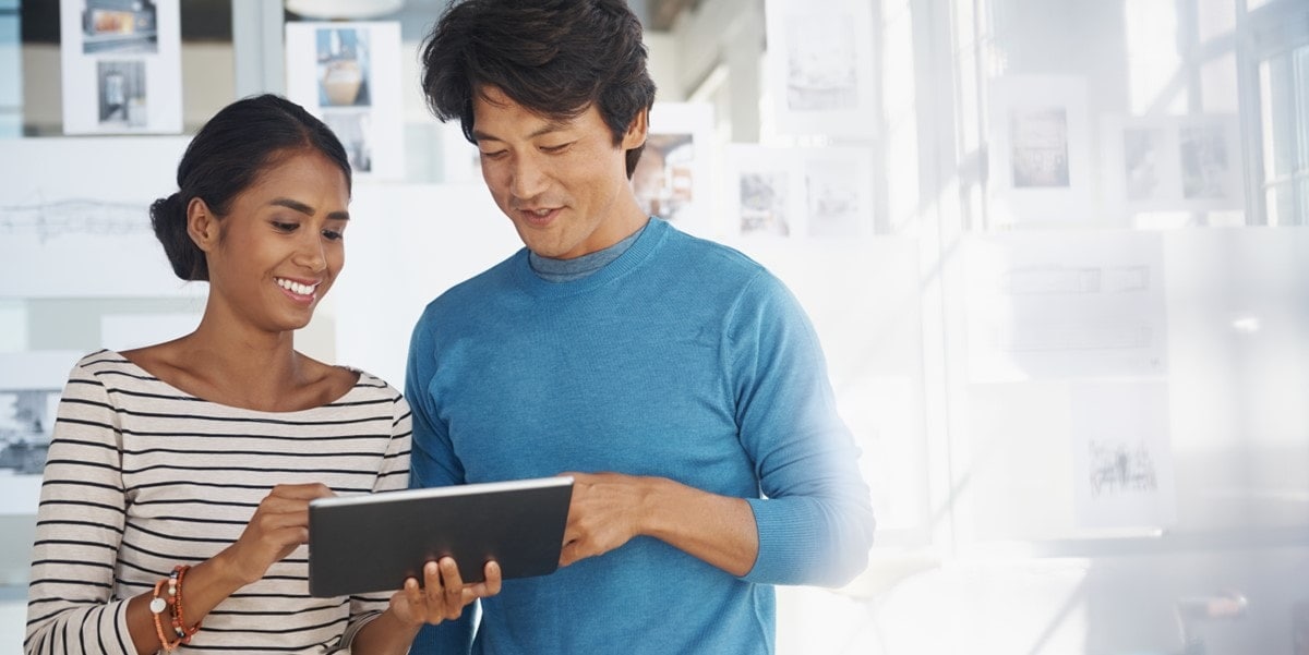 two people looking at a tablet in office
