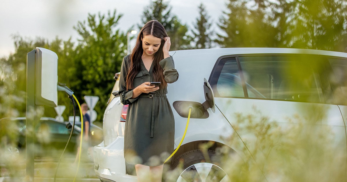 lady charging electric car looking down