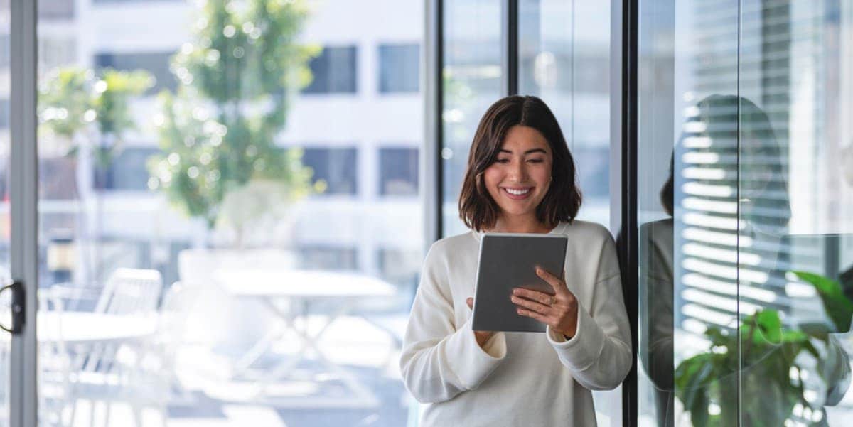 woman smiling looking at her tablet