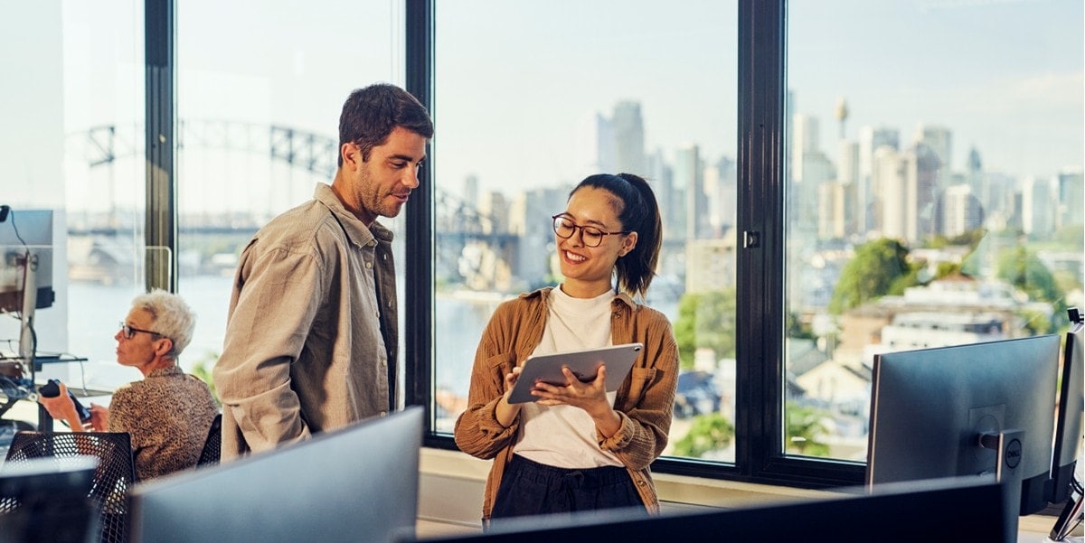two professionals in the office looking at tablet