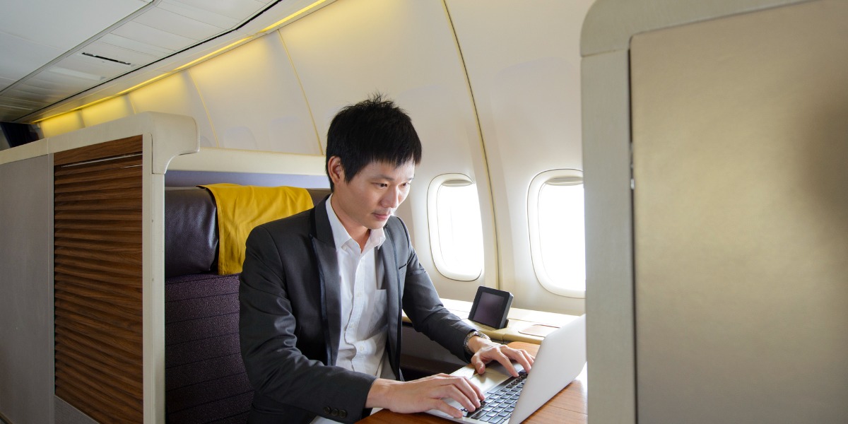 business man working on a laptop on a plane