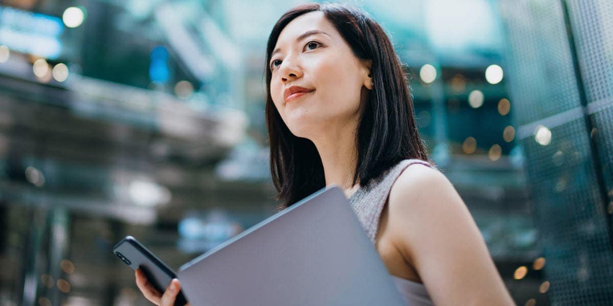 woman holding laptop and mobile