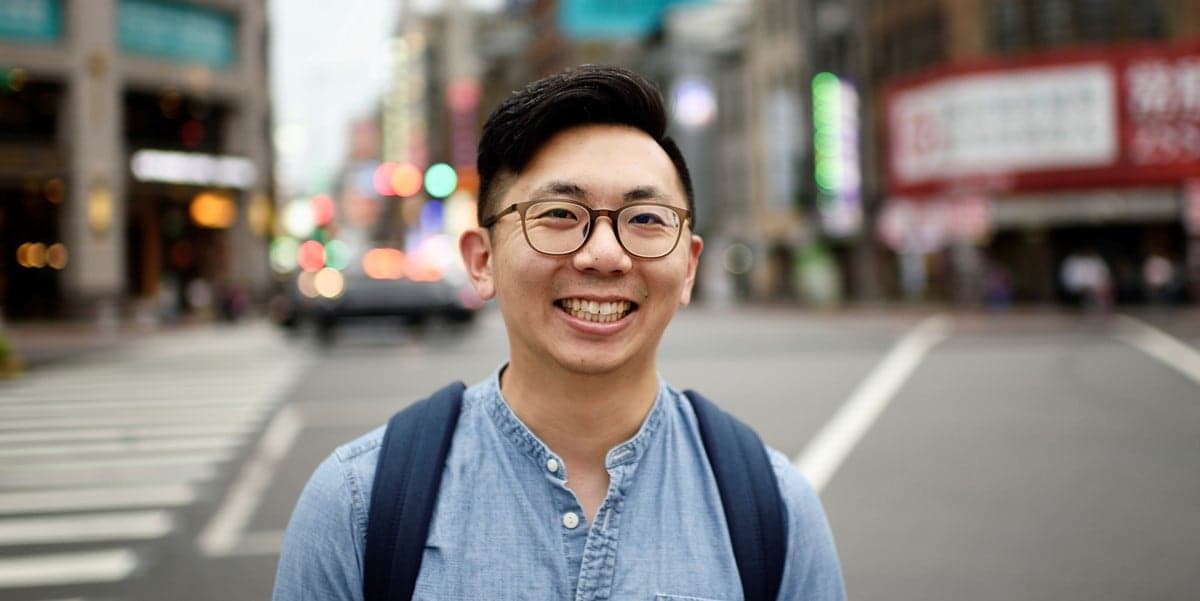 man smiling outside, city street