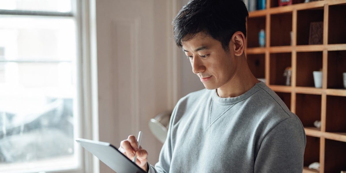 man writing on tablet, office