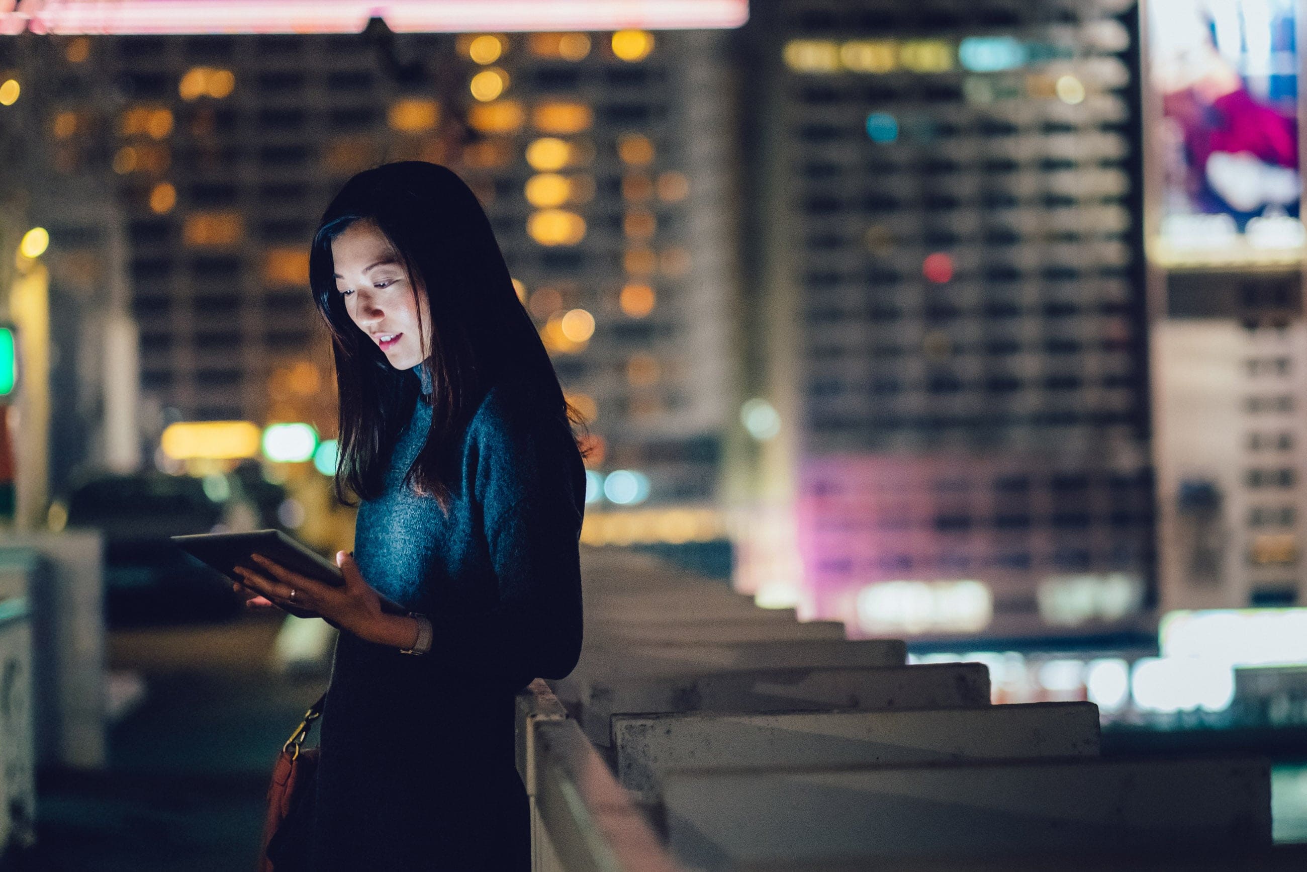 woman looking at her phone on a city rooftop