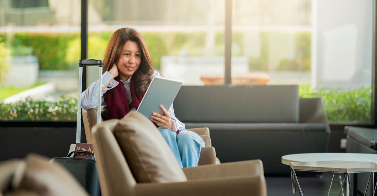 business traveler sitting down and looking at a tablet