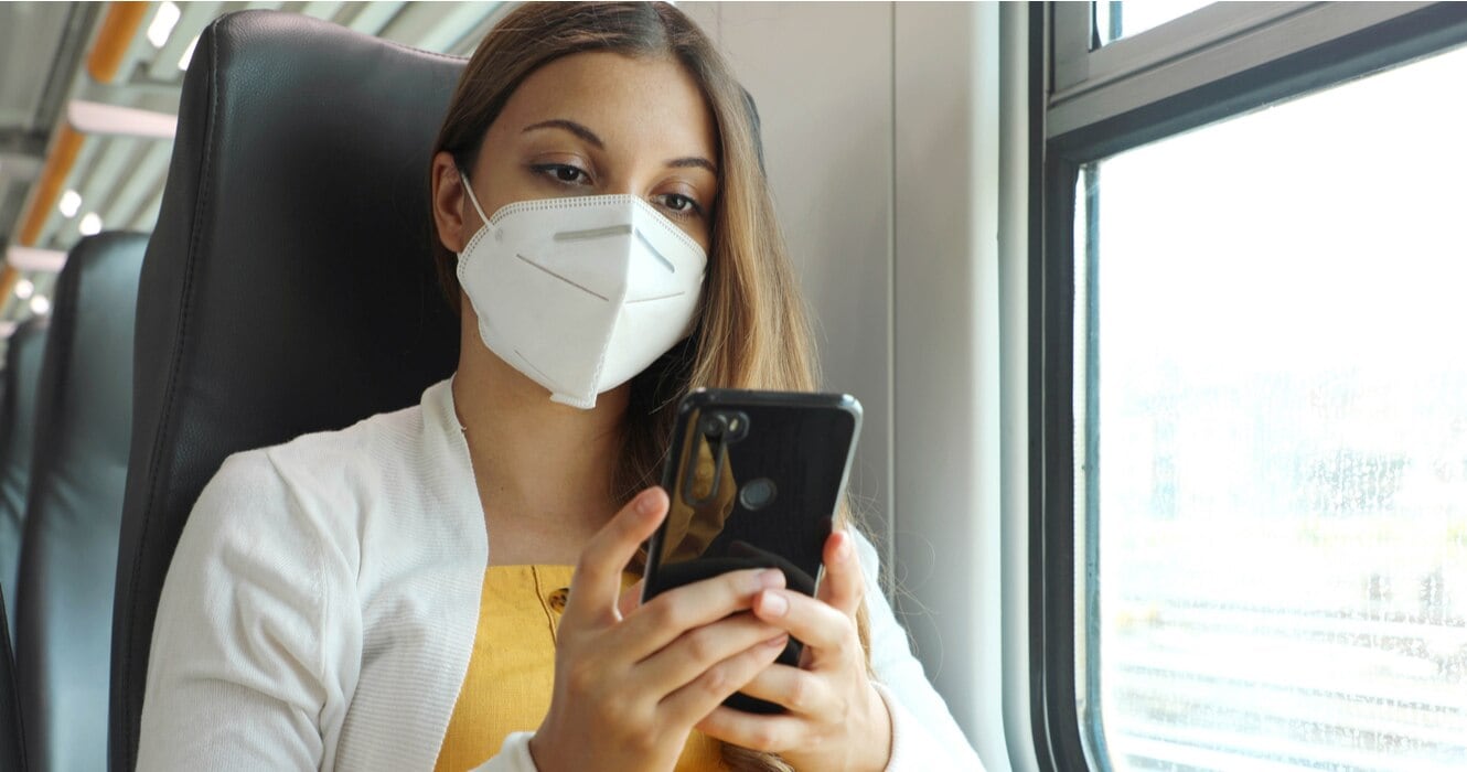 woman in mask using phone