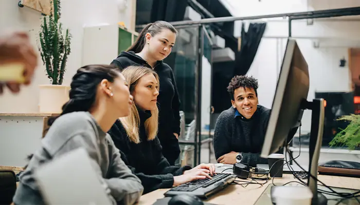 group on four people discussing work on a laptop