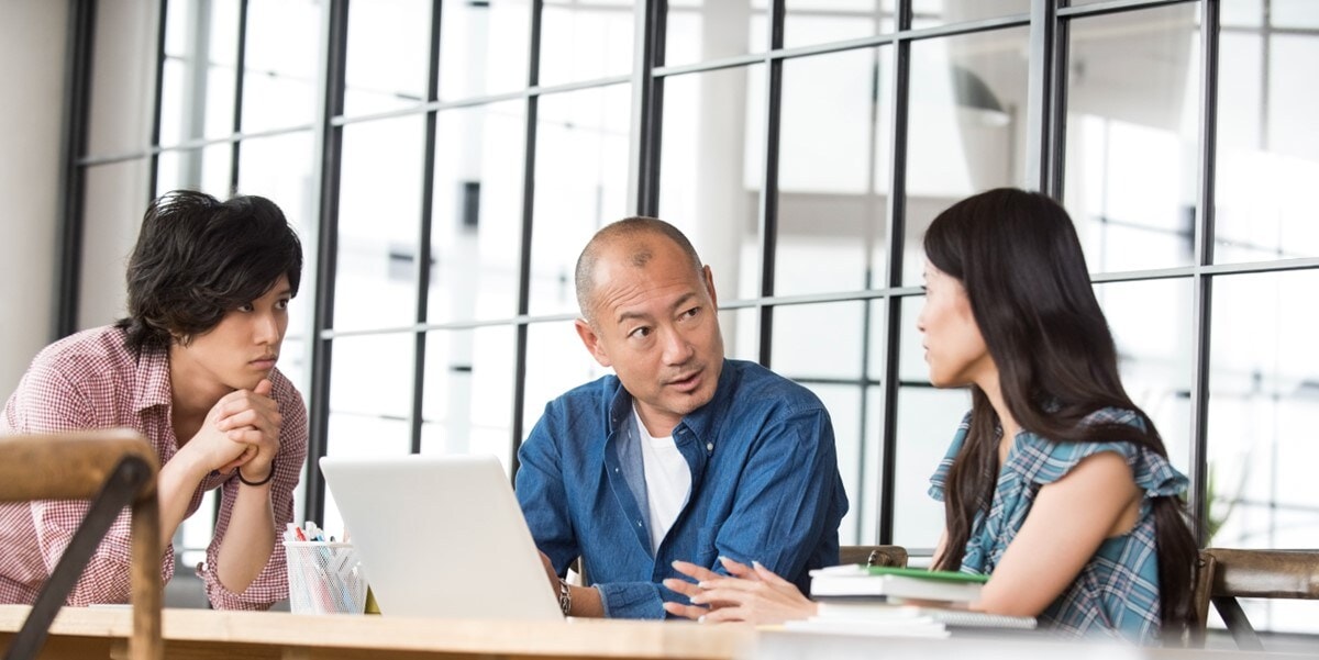 3 people in meeting aorund table