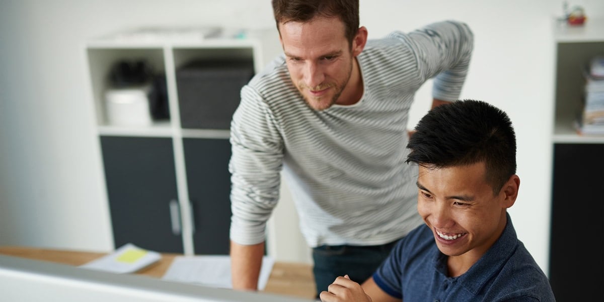 two men looking at a tablet